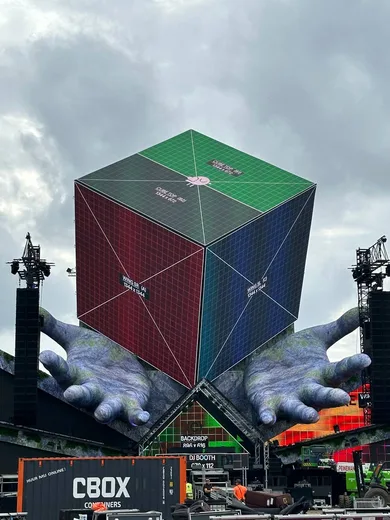 Main stage: an LED cube held by giant hands